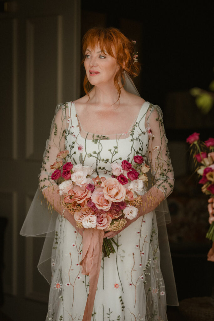 Bride holding a bouquet in natural window light before her ceremony in Glasgow.