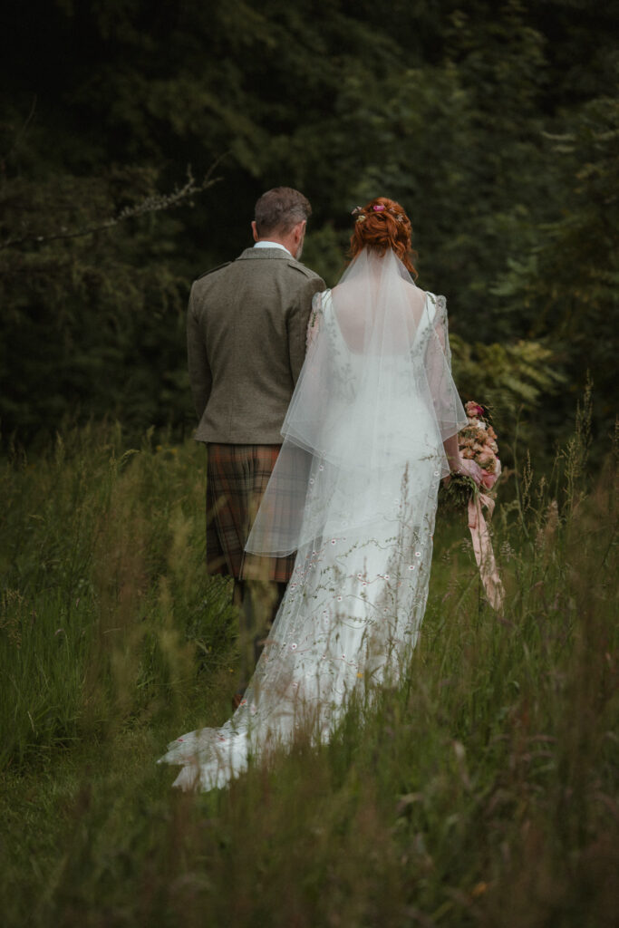 Natural wedding photography in Ayr. Candid moment of a couple walking outdoors during their wedding day.