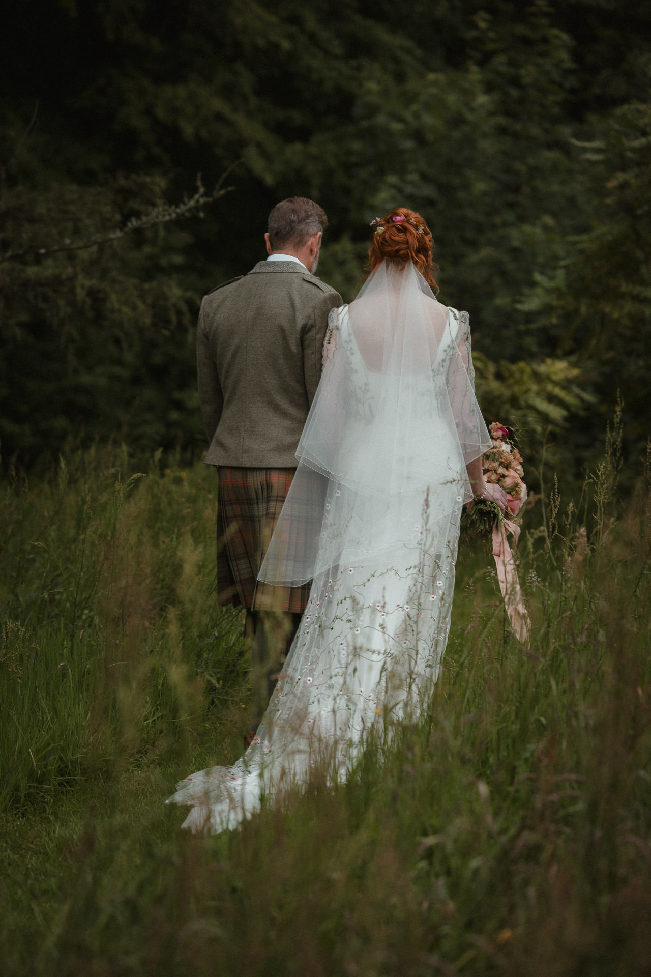 Natural wedding photography in Ayr. Candid moment of a couple walking outdoors during their wedding day.