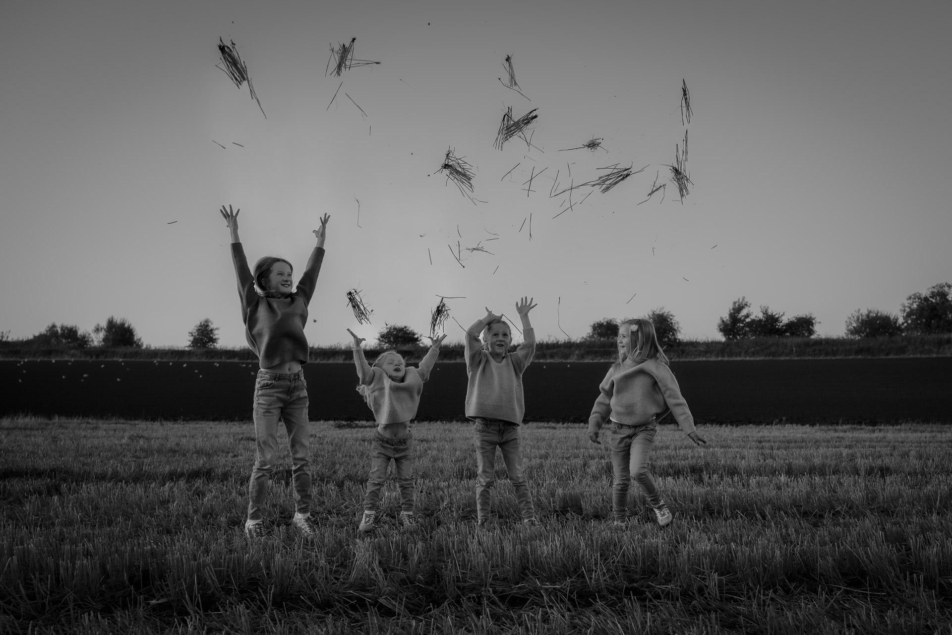 Candid family moment, four girls playing together during a relaxed outdoor photoshoot in Scotland.