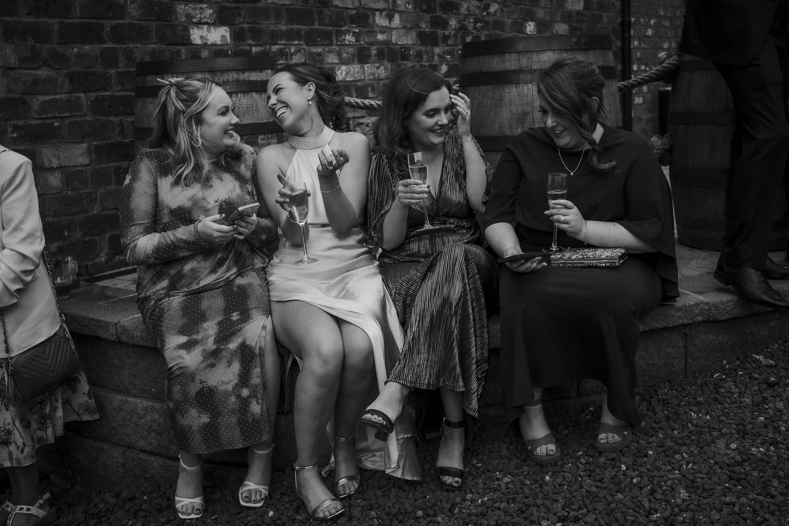 Bride sharing a relaxed, joyful moment with friends outside during the wedding reception.