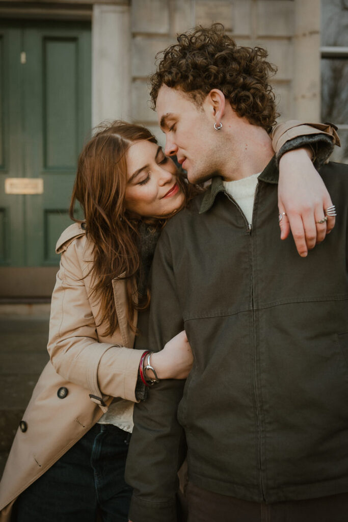 Engaged couple embracing on the street.