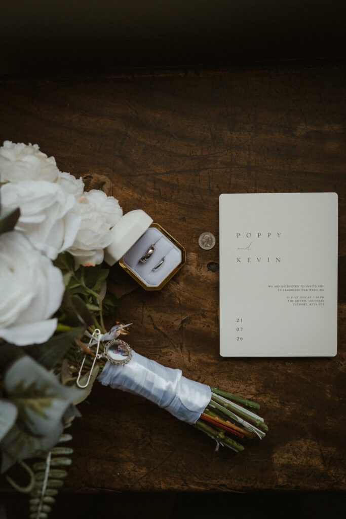 Bouquet, wedding invitation and silver sixpence.