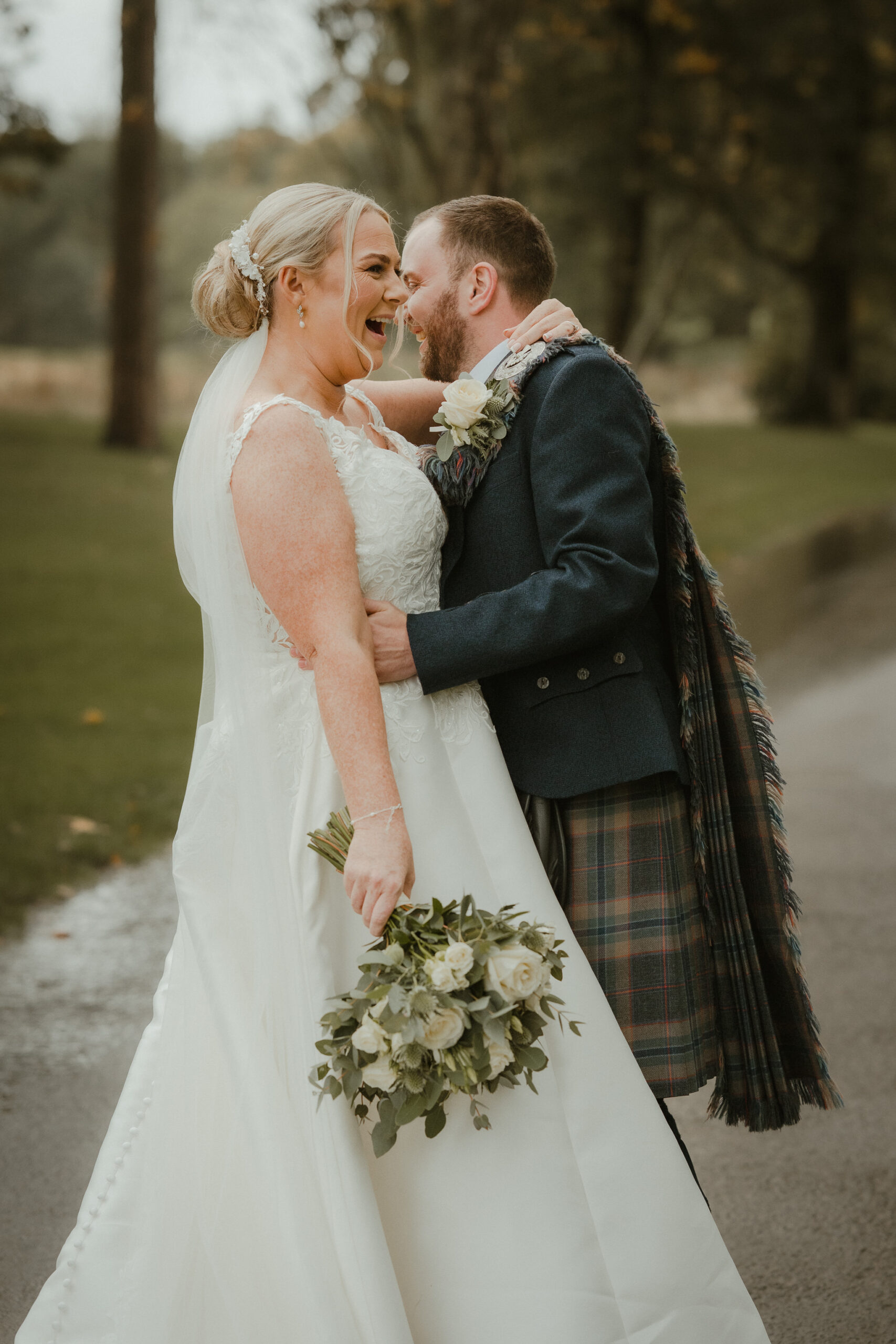 Bride and groom laughing together on the drive at Enterkine House, Ayrshire